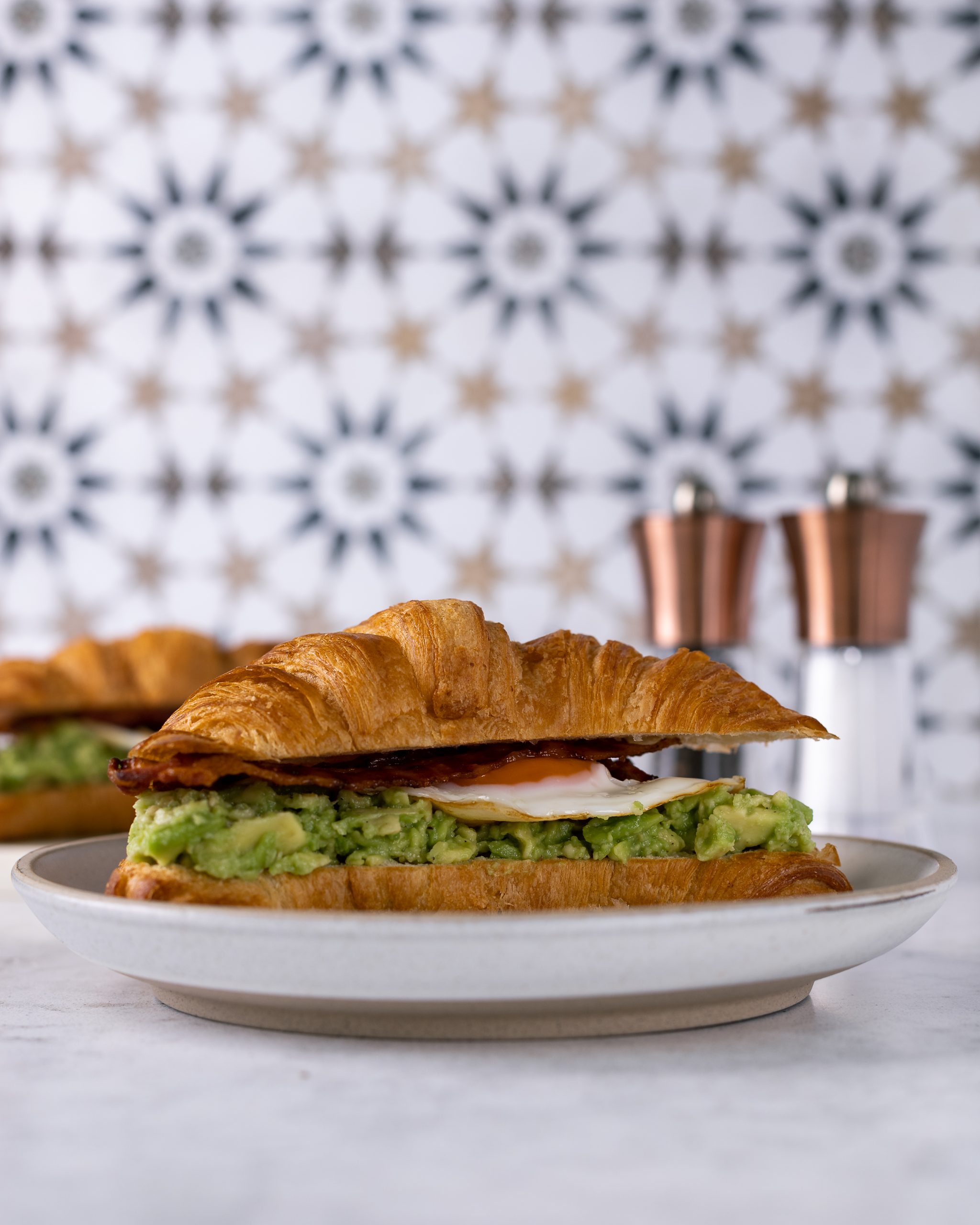 The ultimate brunch with loaded croissants. Croissant with avocado smash with a pinch of chilli flakes, rich fried egg with crispy bacon.