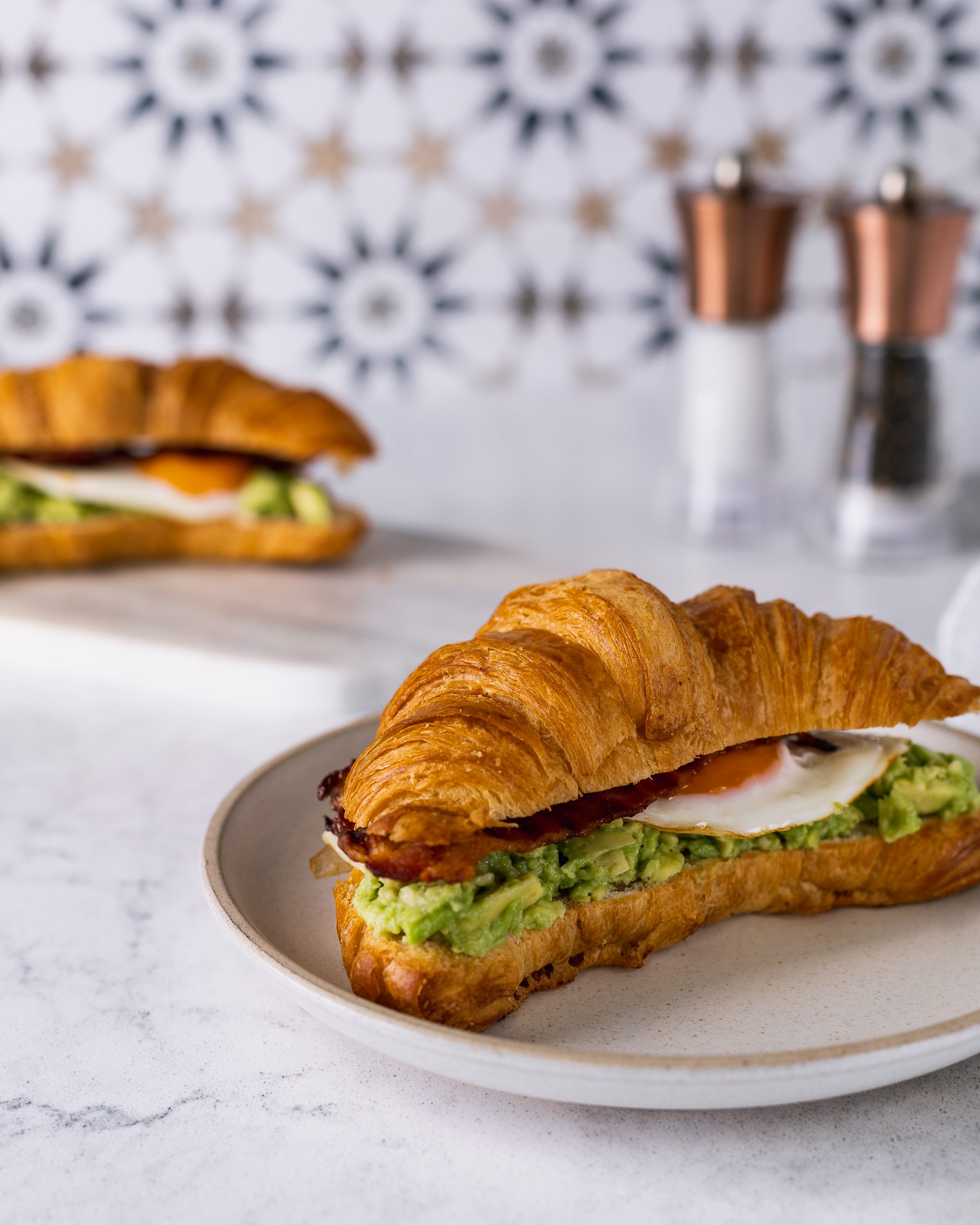 The ultimate brunch with loaded croissants. Croissant with avocado smash with a pinch of chilli flakes, rich fried egg with crispy bacon.